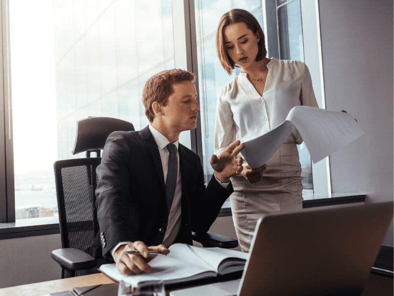 Business people discussing contract documents in office.