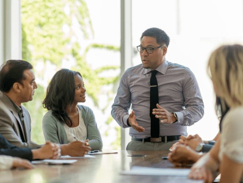 A group of young business professionals attending a presentation in a board room.