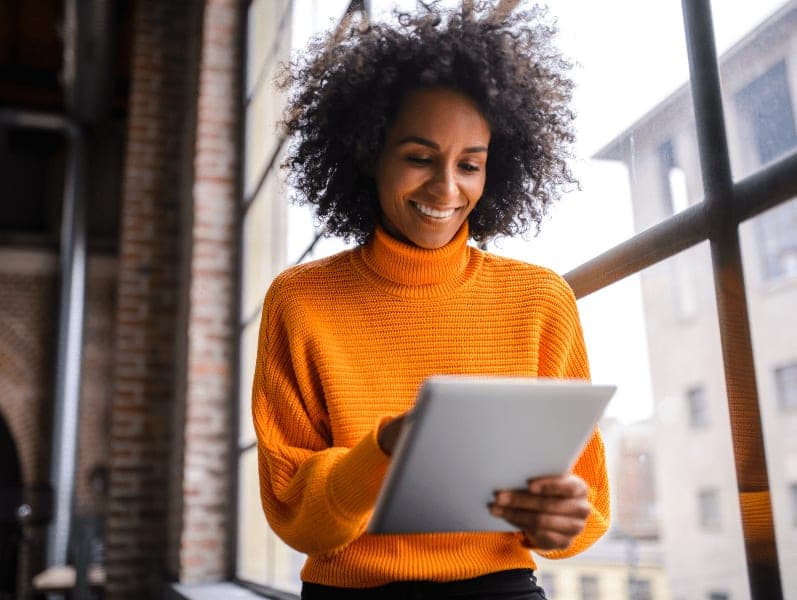 Smiling African American woman using digital tablet at the work.