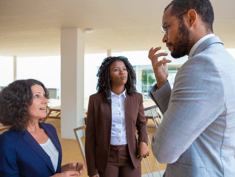 Professional multiethnic business team standing on stairs and talking