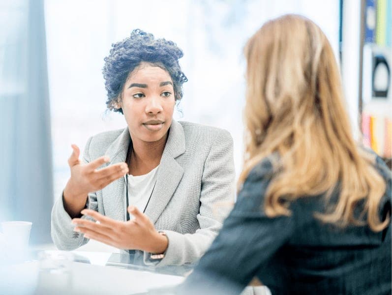 Two women having a serious discussion during their one-on-one meeting.
