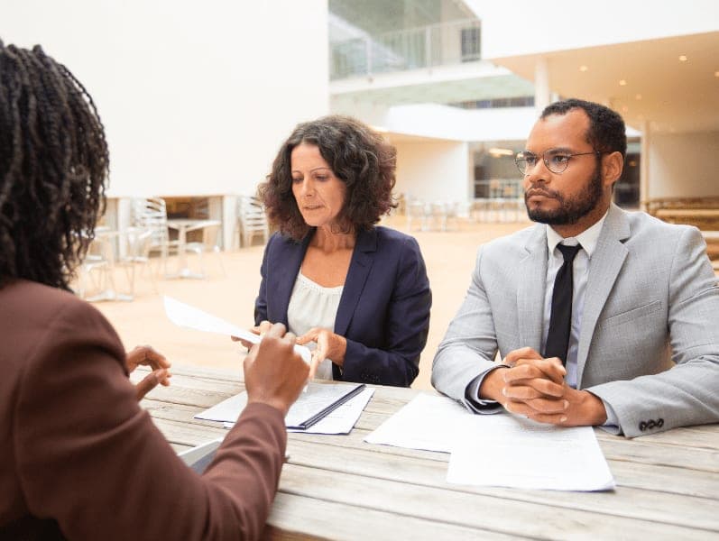 Businessman and women sitting at café with papers on the table.