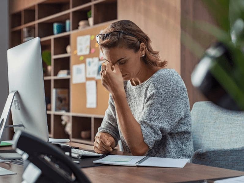 Exhausted businesswoman having a headache in office.