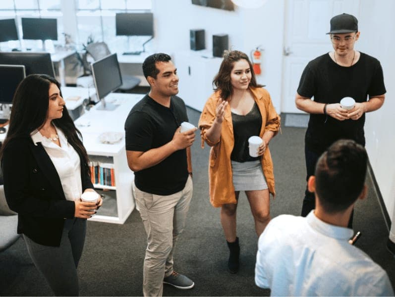 Young Hispanic and Latin entrepreneurs stand around a dry-erase board, brainstorming ideas and strategy at office.