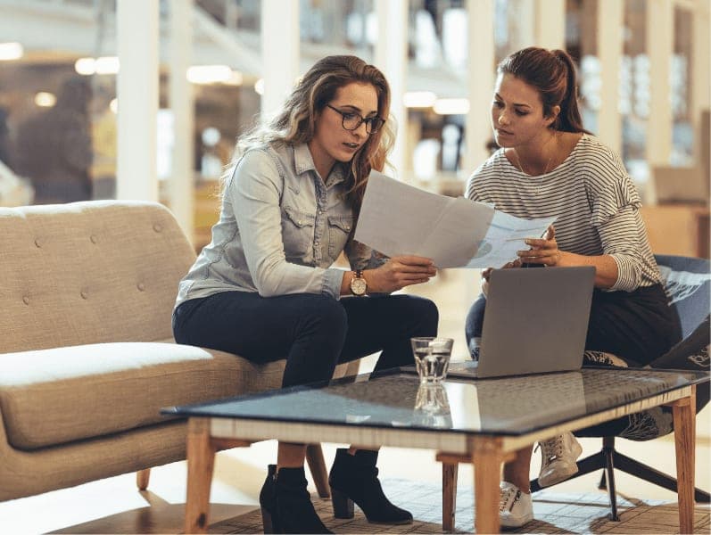 Women entrepreneurs discussing work in office.