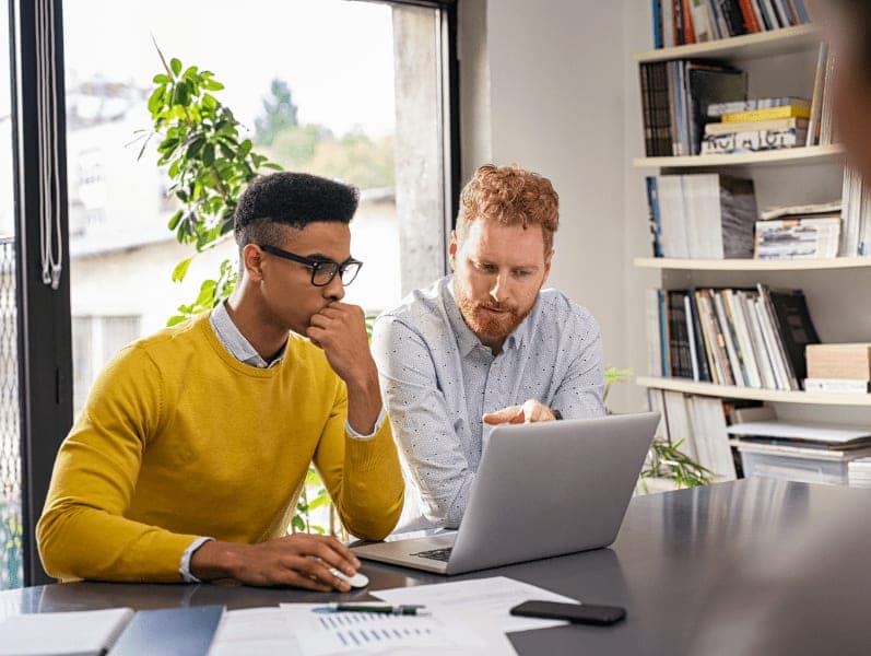 Business executive working with apprentice in creative office.