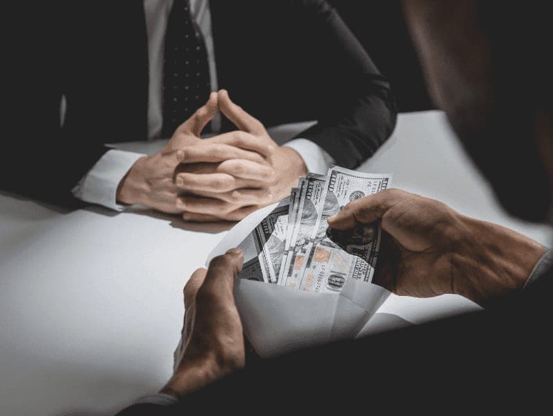 Businessman giving dollar bills o business manager to deal contract.