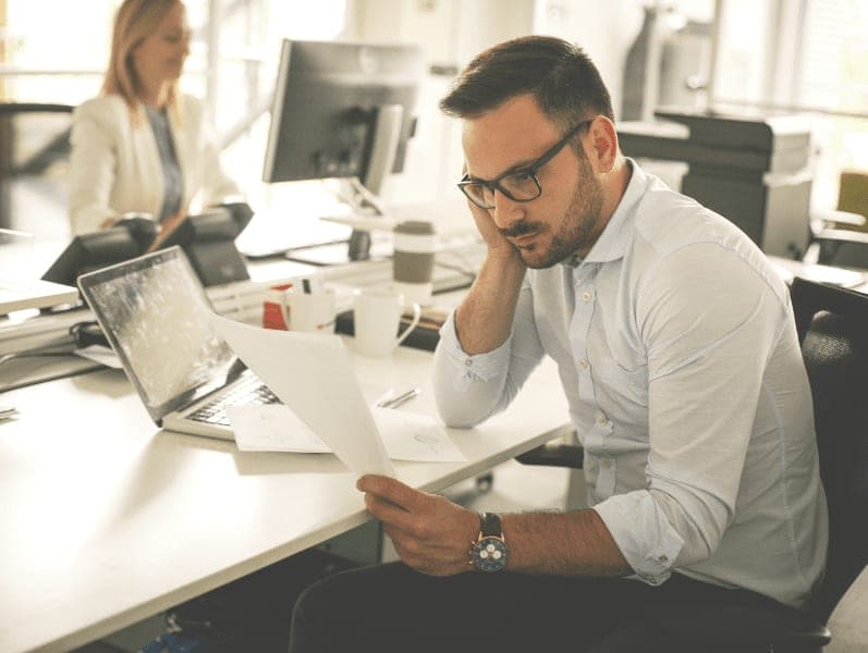 Employee reading a document and thinking.