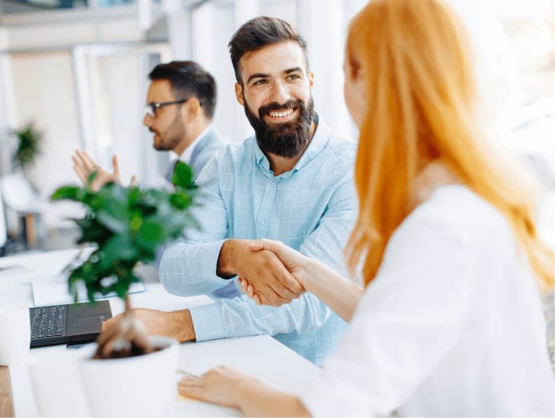 Happy businessman shake hands with female client at the office.