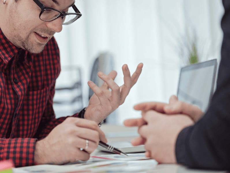 Male employee explaining the document to client.
