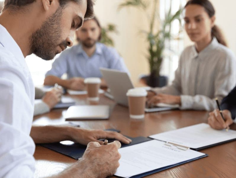 Employee signing a contract in HR office.
