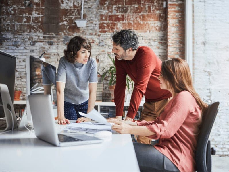 Three employees discussing work in the modern office.