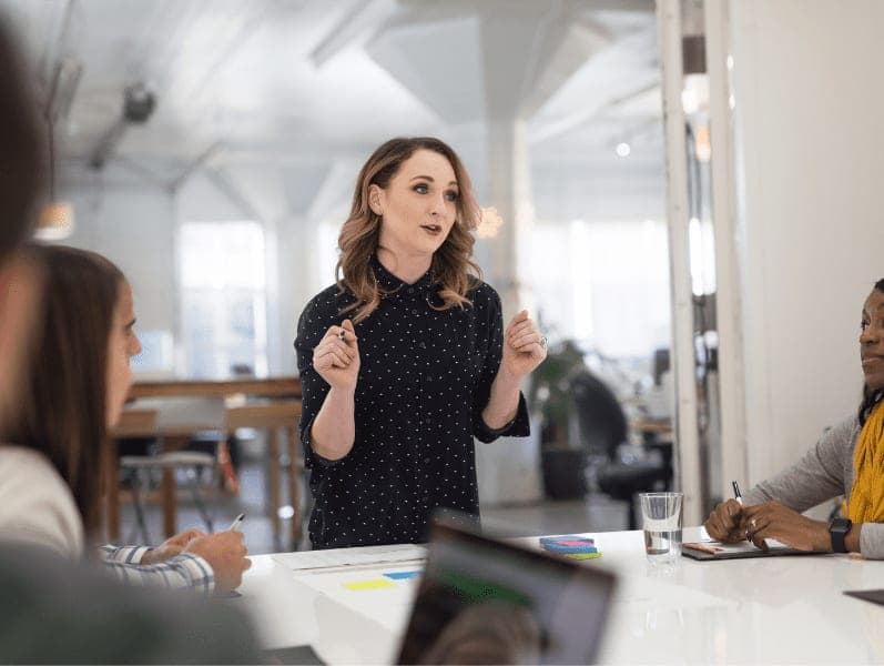 Female employee standing and leading the discussion.