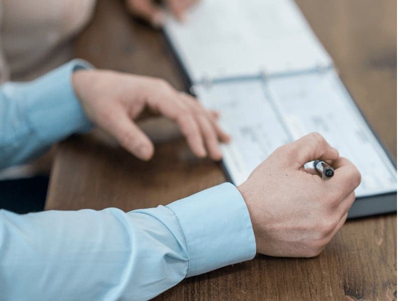 A business associate is writing checks in the office.