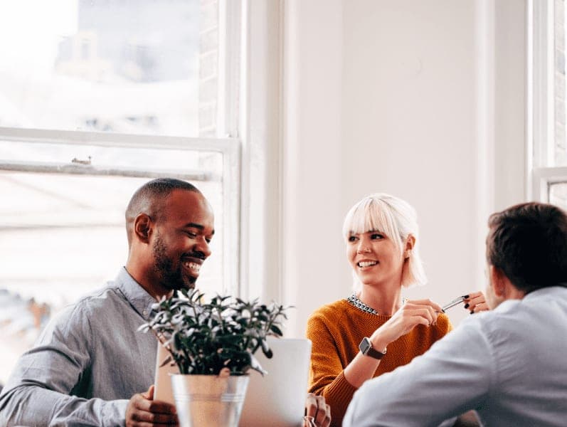 Three people having a conversation in an office