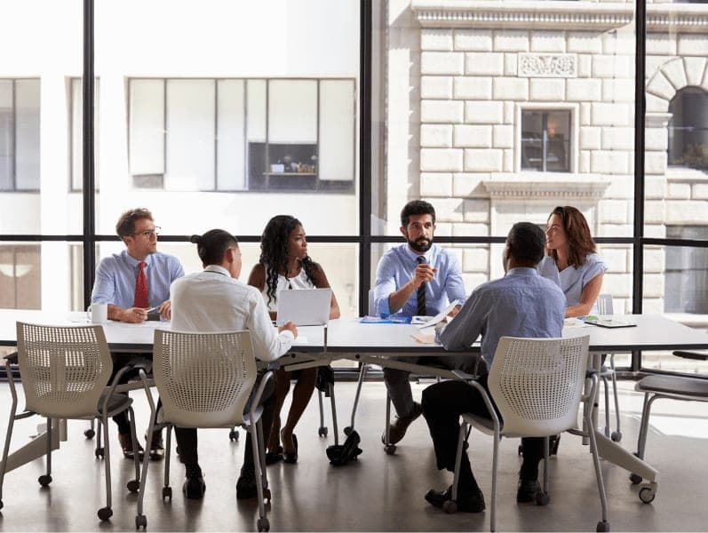 Business team listening to their manager at meeting in the office