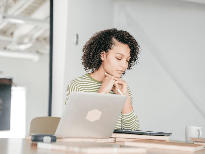 Young woman sitting in an office reflecting on her career goals
