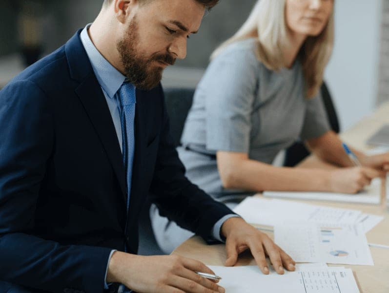 Businessman reading document during meeting.