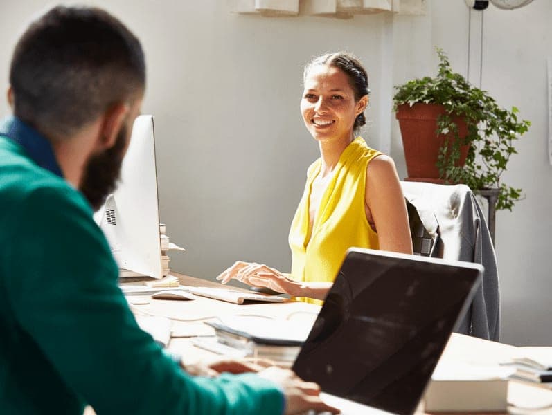 Employees sitting across from each other speaking about S corps