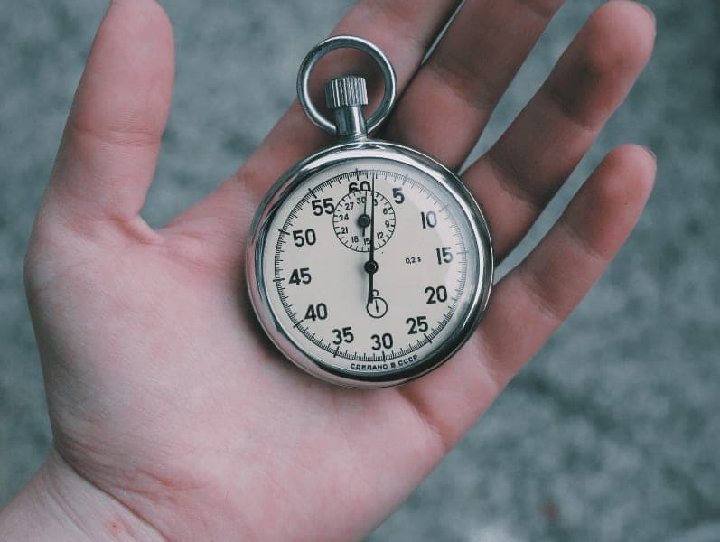 Male hand with palming facing up holding a vintage stop watch