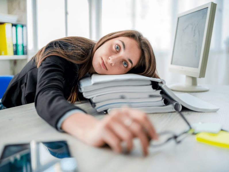 Female resting head on work books felling anxiety