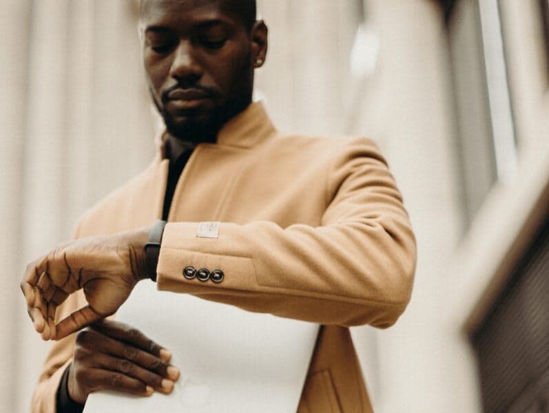 Man walking outside checking his watch for the time