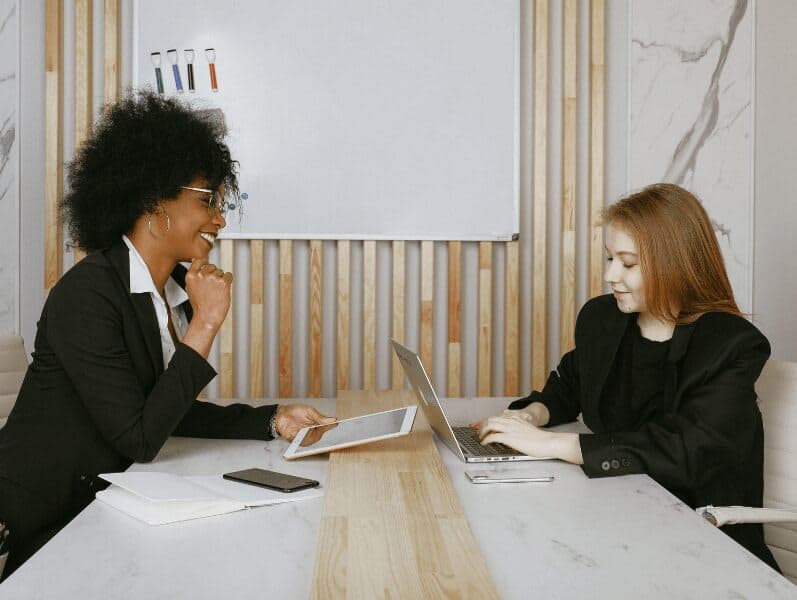 Female employees sitting at a desk reviewing LLC's and S Corps
