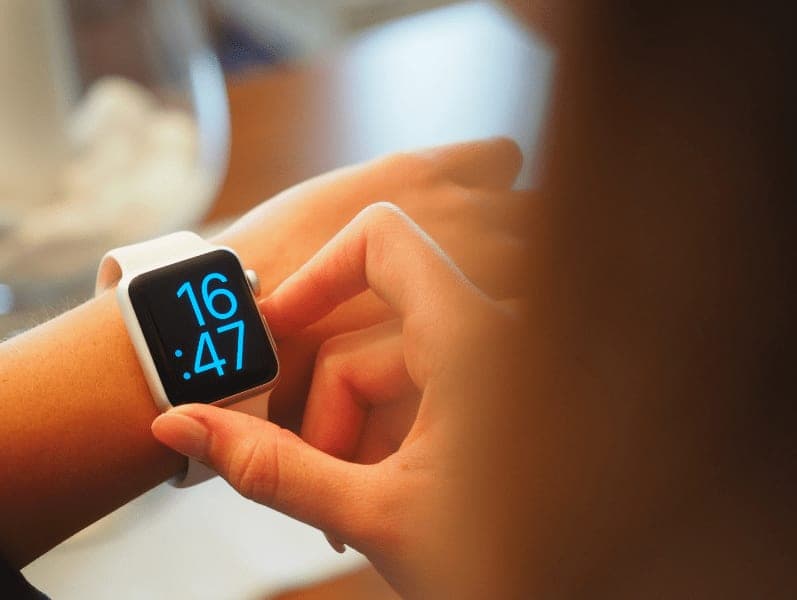 Female holding up her apple watch to check her time
