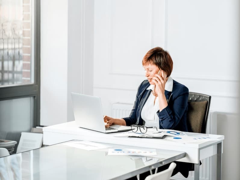 Female accountant sitting at her desk calling leads.