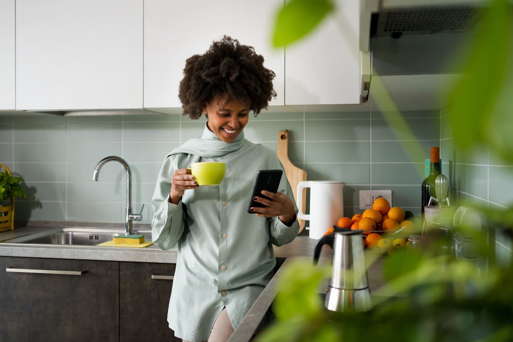 A happy woman at home using her phone