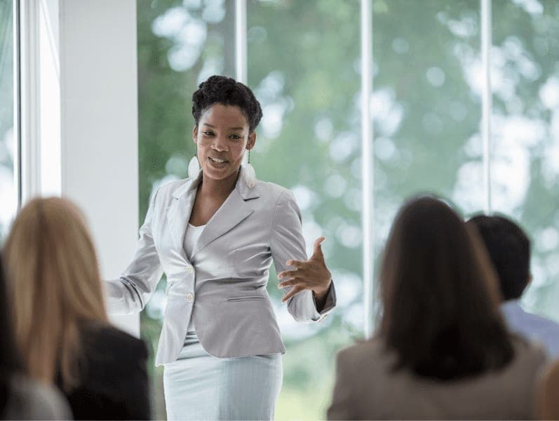 A woman giving a presentation in front of her colleagues.