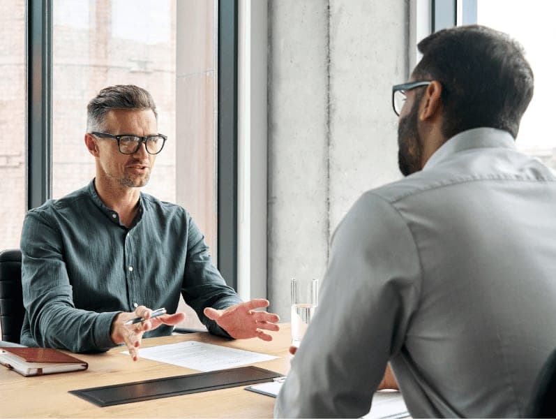 Two diverse business executive partners negotiating at board meeting.