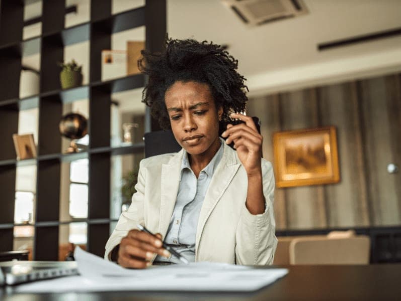 Woman looking confused while doing paperwork.