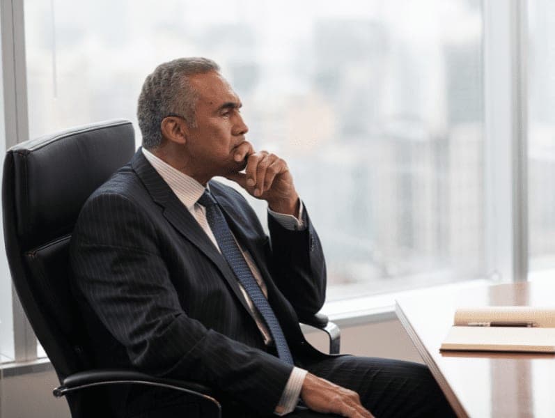 Businessman sitting in the boardroom thinking.