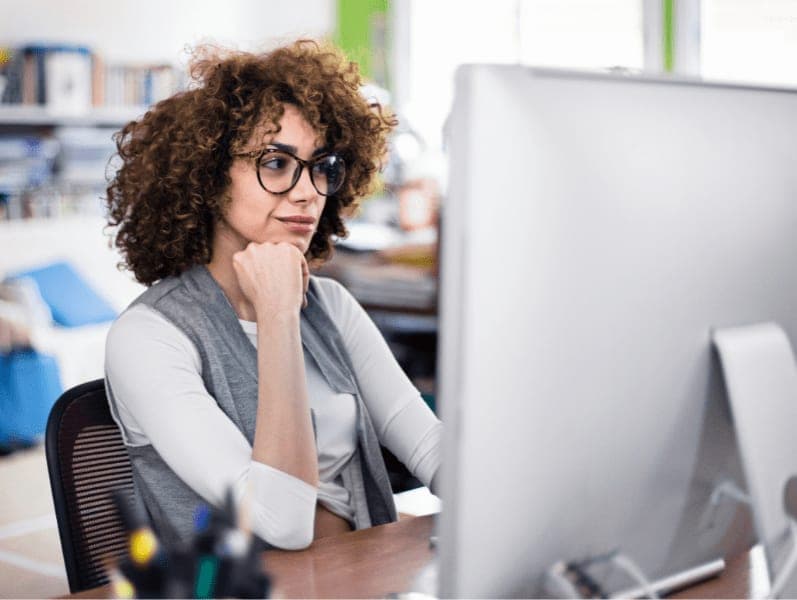 Businesswoman thinking about work with her hand on chin.