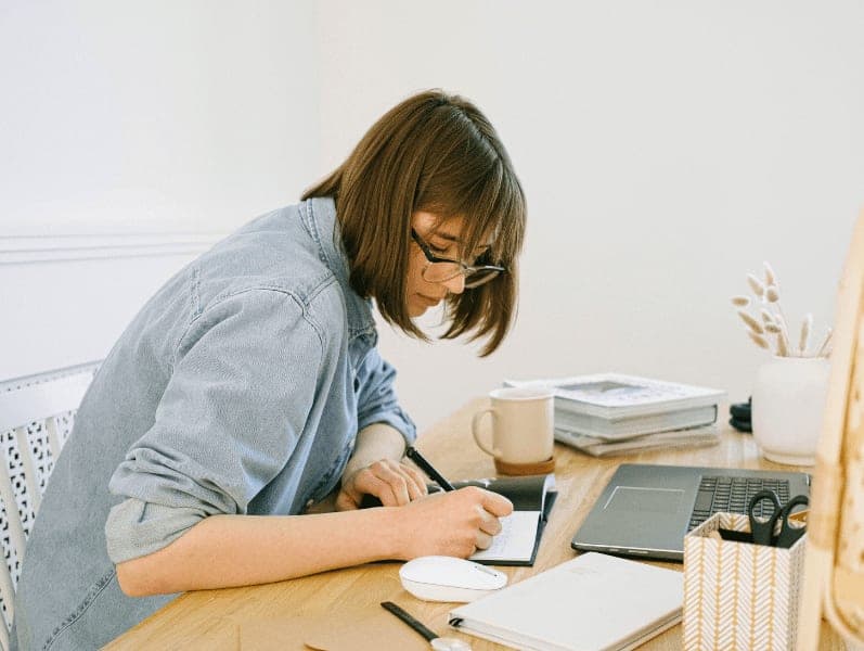 Woman writing on a notebook.