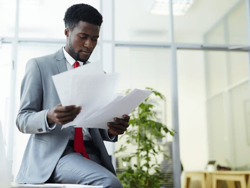 Accounting professional looking through financial papers in office.