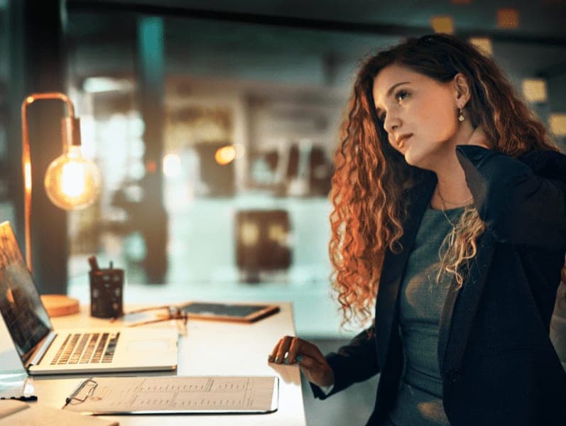 Businesswoman suffering from neck pain while working late.