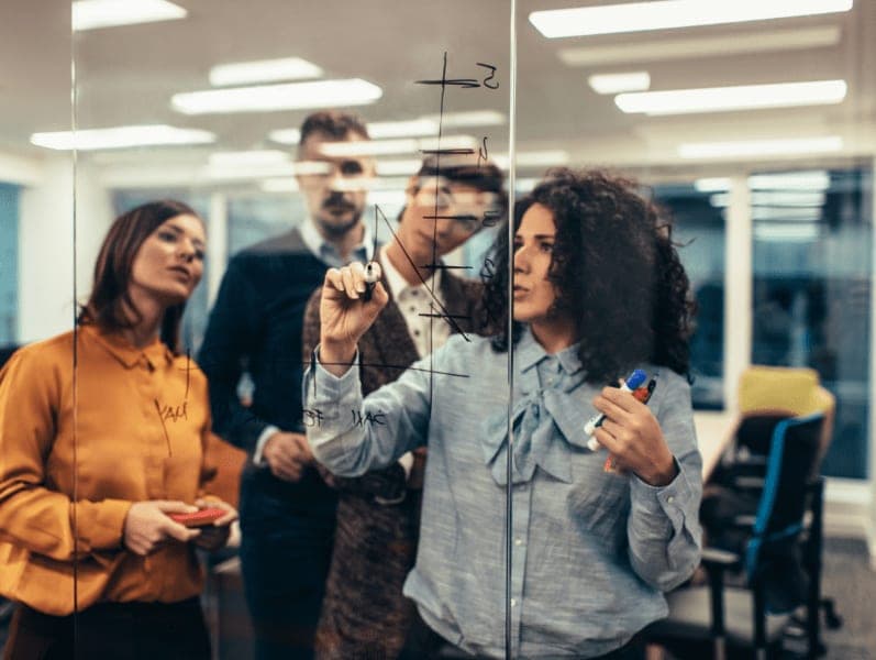 Business people standing by the glass wall and discussing.