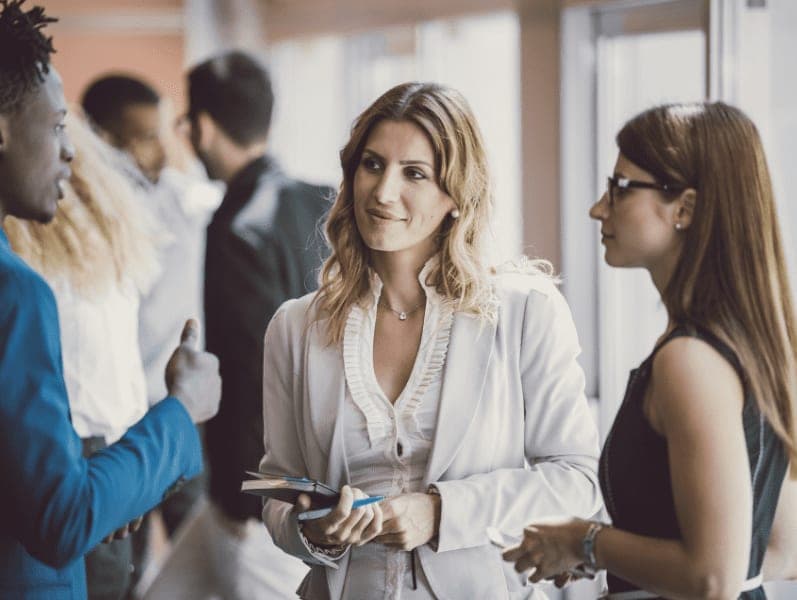Three people having a conversation at a seminar.