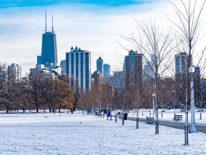 Snow covered park in Chicago with skyline.