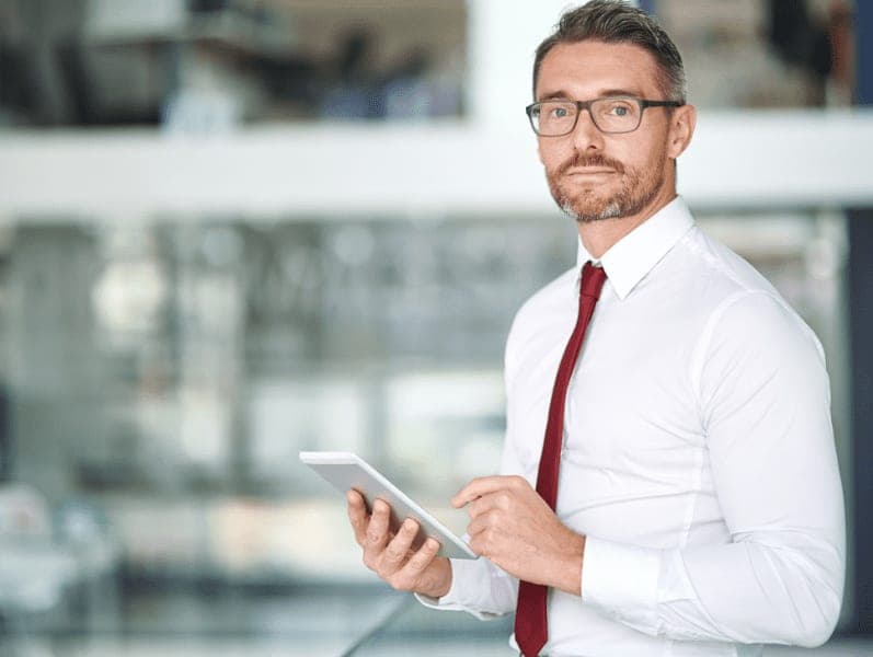 Mature businessman using a digital tablet in an office.