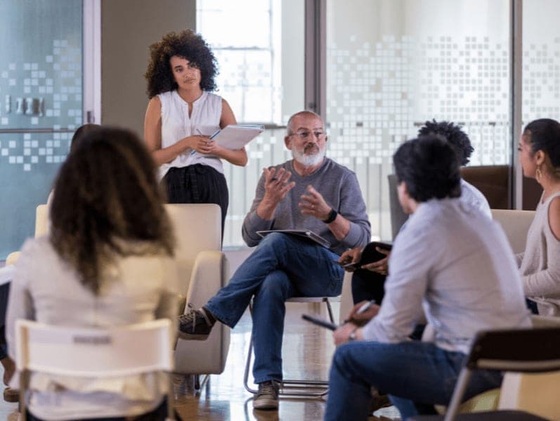 Diverse group of employees meet casually with senior management.