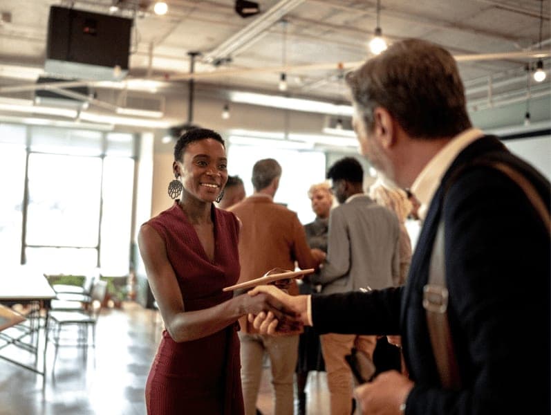 Business people shaking hands at business event.