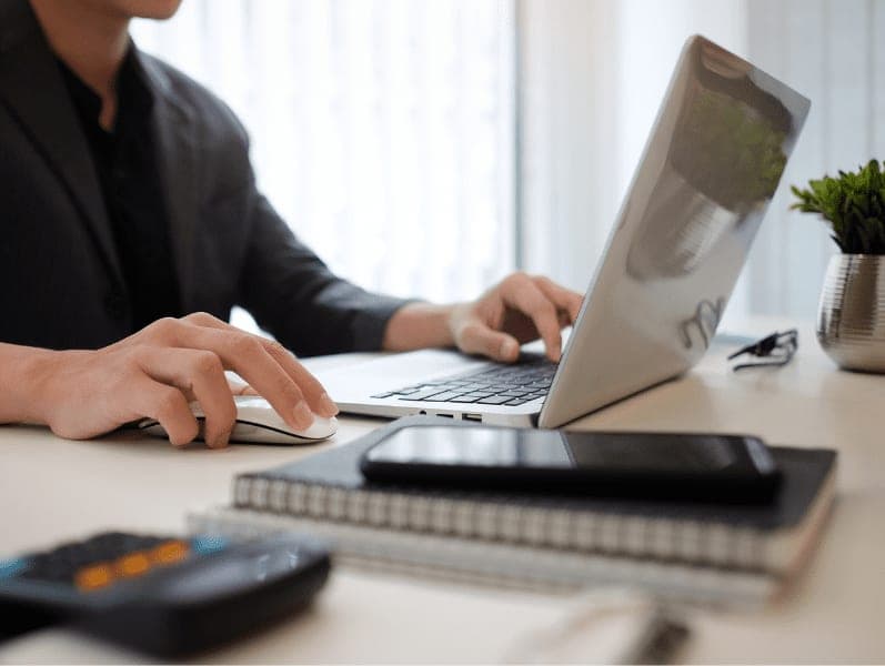Accountant working with laptop computer at office desk.