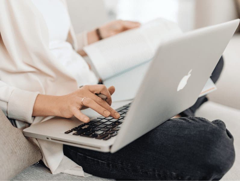 Person in white long sleeve shirt using MacBook.