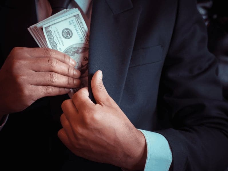 Businessman is hiding money in his pocket.