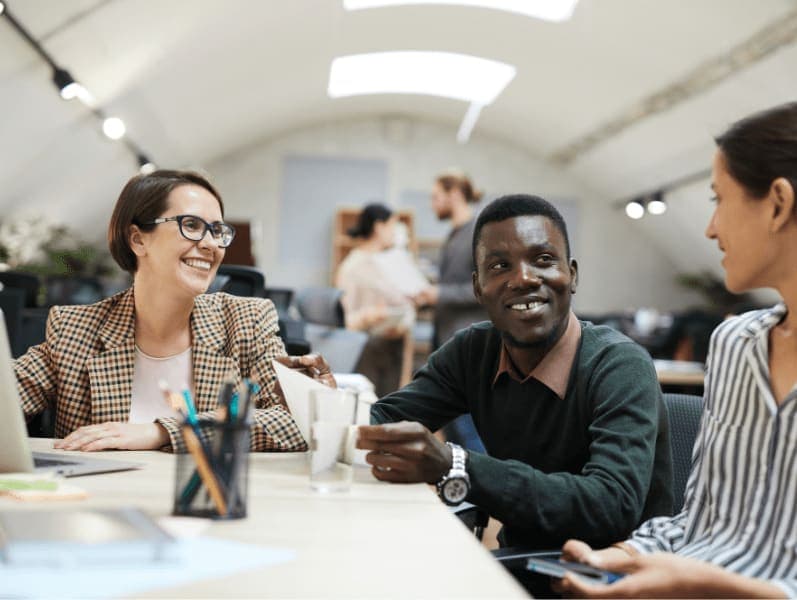 Multi-ethnic group of people smiling happily while working together in office