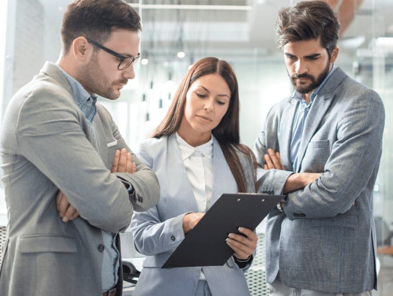 Business woman showing a document to colleagues at workplace