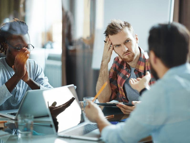 Serious businessman listening to colleague at meeting